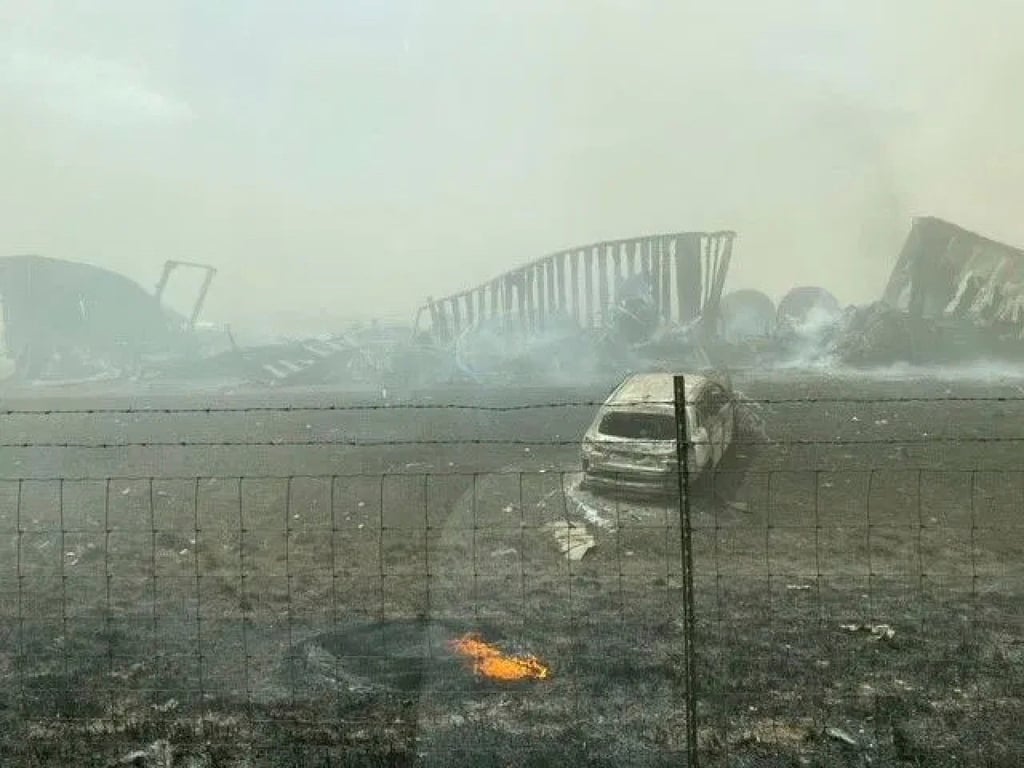 Smouldering wreckage is seen after a crash that shut down a highway in Illinois on Monday. Photo: WICS TV via AP