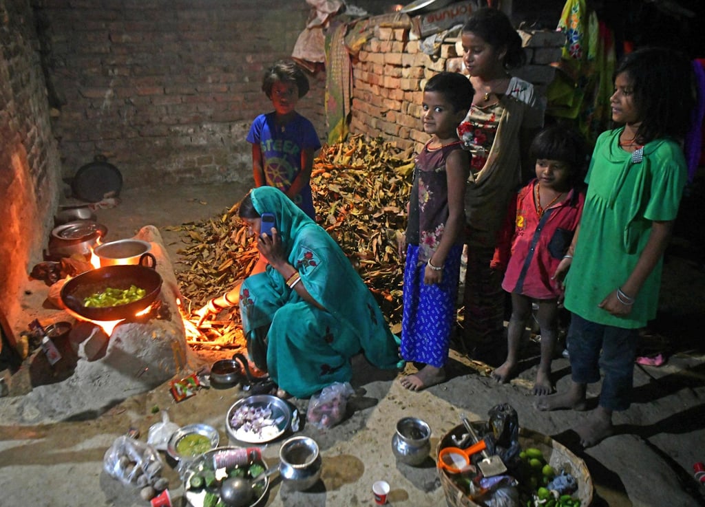 Jaimala Devi, mother-of-seven, cooks food as her children watch inside their village house in India’s Bihar state. Photo: AFP