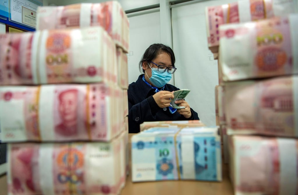 A clerk counts renminbi banknotes at a bank outlet in Hai’an city in eastern China’s Jiangsu province. Photo: AP