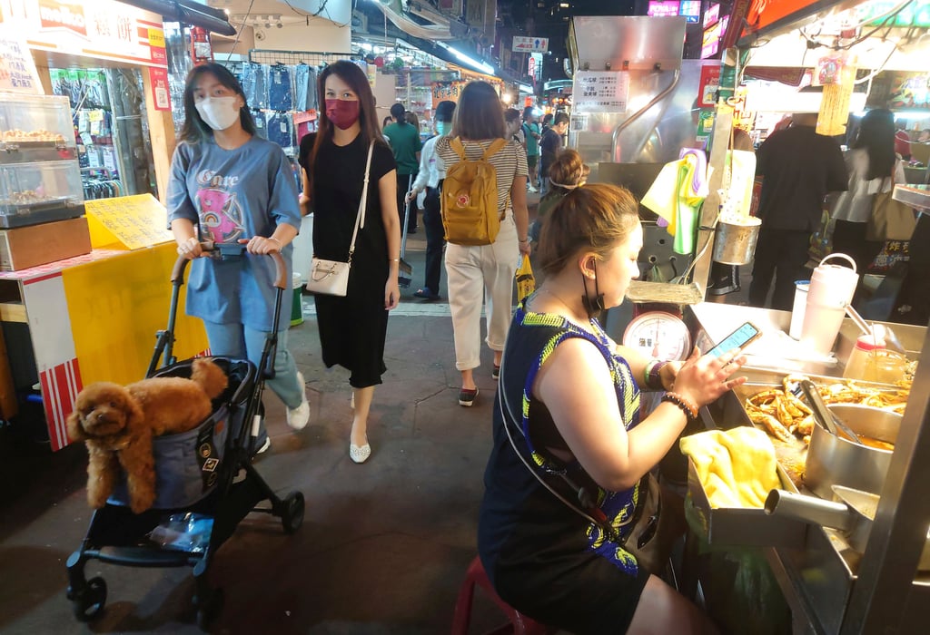 People wear face masks to protect against the spread of the coronavirus at a night market in Taipei last month. Photo: AP
