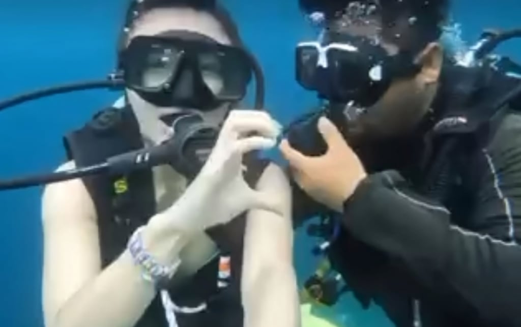 The Malaysian diving instructor is seen pulling his regulator out of his mouth as he goes in to kiss his Chinese client after making a heart hand with her in this screengrab from a video. Photo: Facebook/SempornaInfo The Malaysian diving instructor is seen pulling his regulator out of his mouth as he goes in to kiss his Chinese client after making a heart hand with her in this screengrab from a video. Photo: Facebook/SempornaInfo