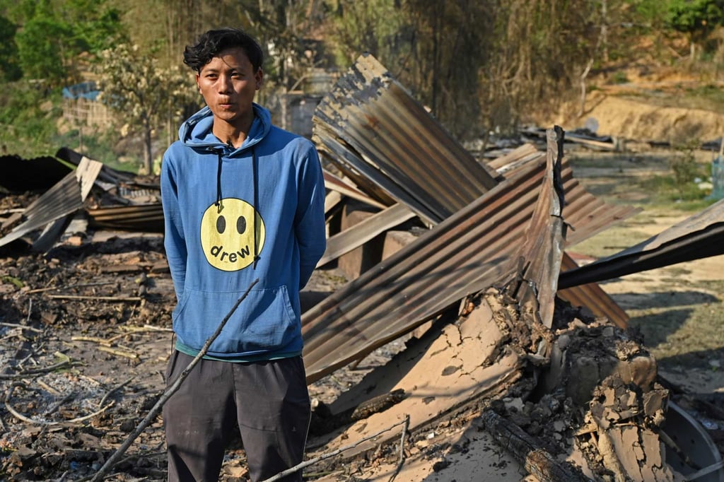 Sanatomba pictured surrounded by the remains of his sister’s house in Heiroklian village, which was set on fire by a mob amid the ethnic violence. Photo: AFP
