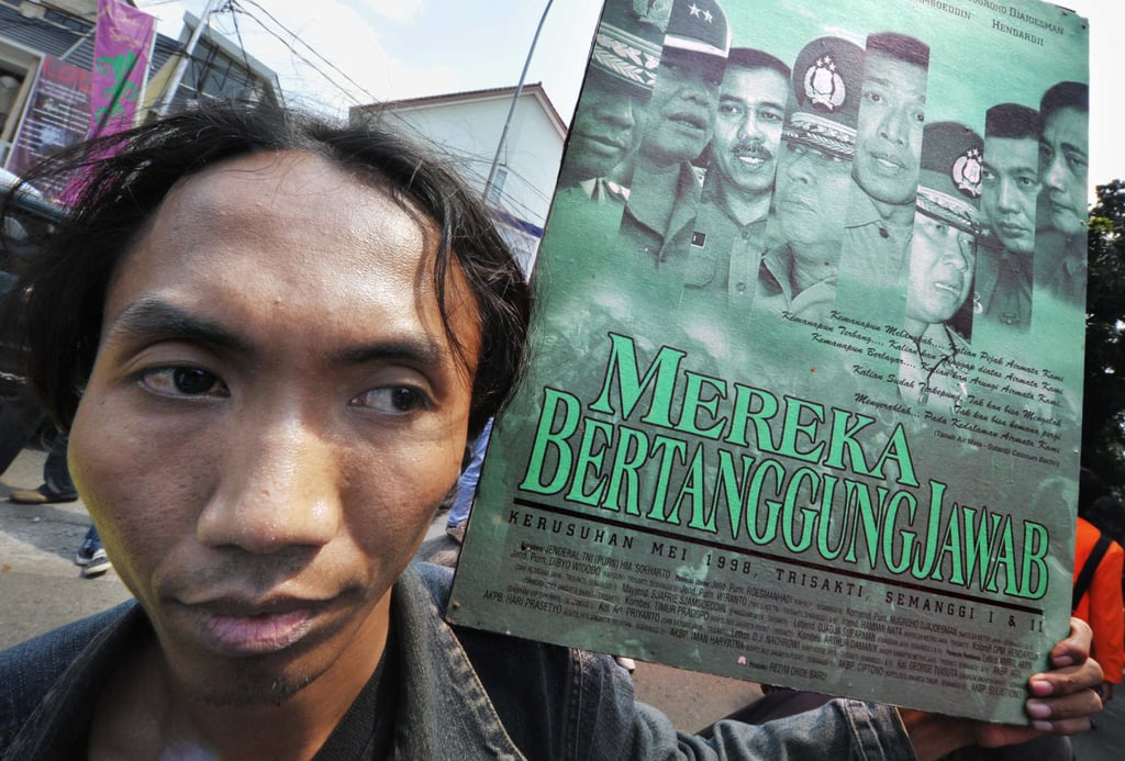 An activist, holding a poster with pictures of the generals involved in quelling protests during the 1998 riots, takes part in a protest marking the 10th anniversary of the fall of the Suharto regime, in Jakarta in May 2008. Photo: AFP