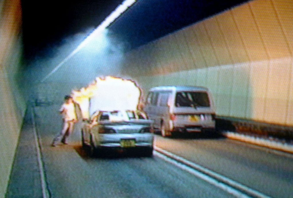 The driver tries to put out the fire that engulfed his car in the middle of the Kowloon-bound section of the Cross-Harbour Tunnel on May 29, 2000. Photo: SCMP The driver tries to put out the fire that engulfed his car in the middle of the Kowloon-bound section of the Cross-Harbour Tunnel on May 29, 2000. Photo: SCMP