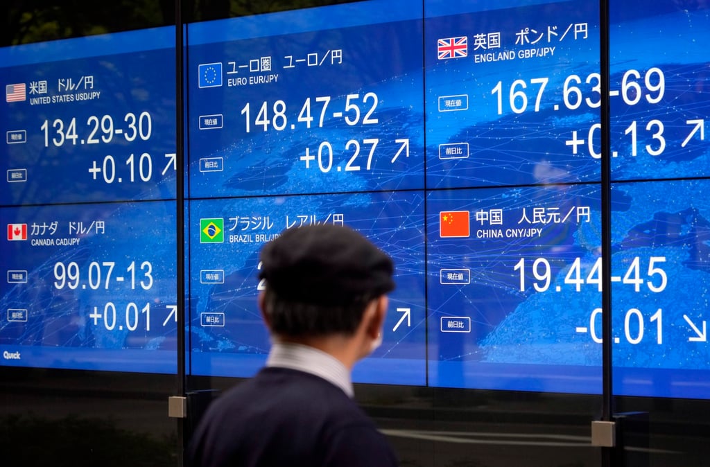A pedestrian looks at a foreign currency indicator board in Tokyo on April 25. Photo: EPA-EFE