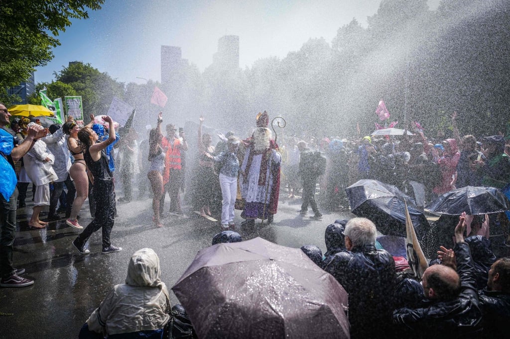Extinction Rebellion activists block a motorway as riot police uses water cannon to disperse them in The Hague, Netherlands on Saturday. Photo: ANP / AFP / Netherlands OUT