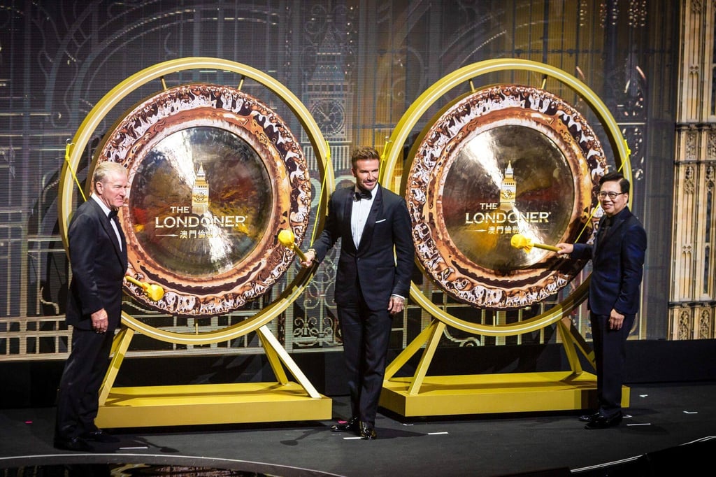 Robert Goldstein, chairman and chief executive officer of Las Vegas Sands Corp. and Sands China Ltd., left, David Beckham, former football star, centre, and Wilfred Wong, president of Las Vegas Sands Corp. and Sands China Ltd., prepare to beat the gong during the opening ceremony at the Londoner Macau casino resort, on May 25. Photo: Bloomberg Robert Goldstein, chairman and chief executive officer of Las Vegas Sands Corp. and Sands China Ltd., left, David Beckham, former football star, centre, and Wilfred Wong, president of Las Vegas Sands Corp. and Sands China Ltd., prepare to beat the gong during the opening ceremony at the Londoner Macau casino resort, on May 25. Photo: Bloomberg