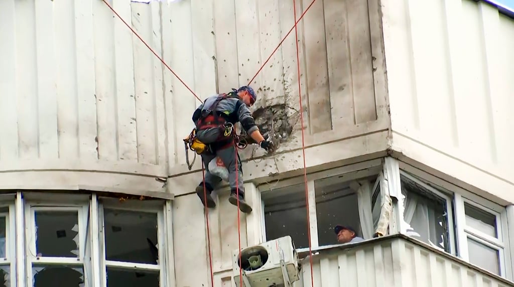 Investigators inspect a building after a Ukrainian drone damaged an apartment building in Moscow. Photo: AP