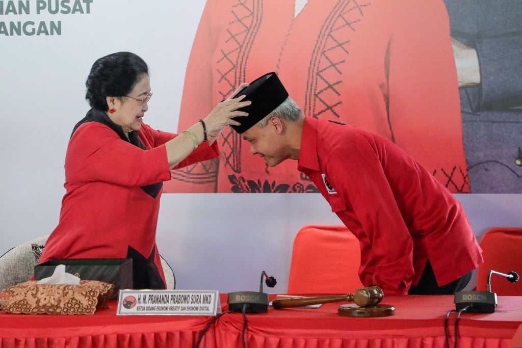PDI-P Chairwoman Megawati Sukarnoputri places a ceremonial hat on Central Java Governor Ganjar Pranowo’s head after he was selected by the party as its candidate for the 2024 presidential election. Photo: AFP