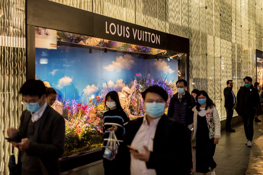 Pedestrians wearing masks walk past a Louis Vuitton store in the Central district of Hong Kong, in February 2020. Photo: Bloomberg Pedestrians wearing masks walk past a Louis Vuitton store in the Central district of Hong Kong, in February 2020. Photo: Bloomberg