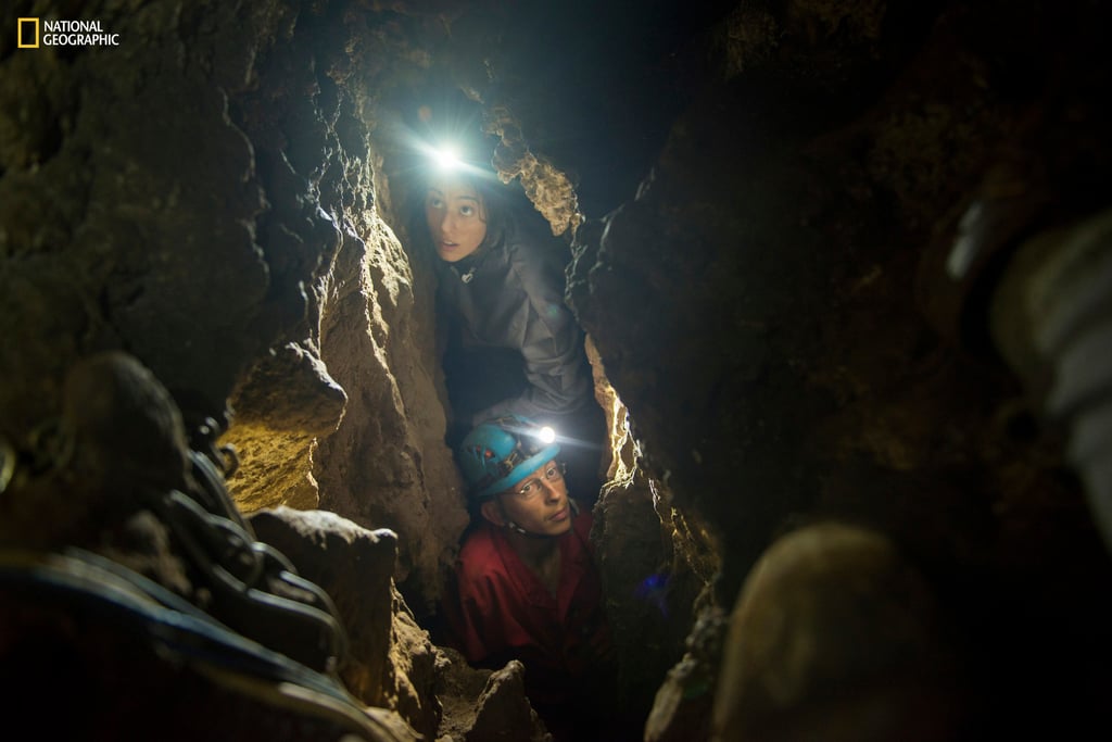 National Geographic Explorer-in-Residence Lee Berger’s daughter, Megan, and underground exploration team member Rick Hunter navigate the narrow chutes leading to the Dinaledi Chamber of the Rising Star Cave in South Africa in 2014. Photo: National Geographic via AP