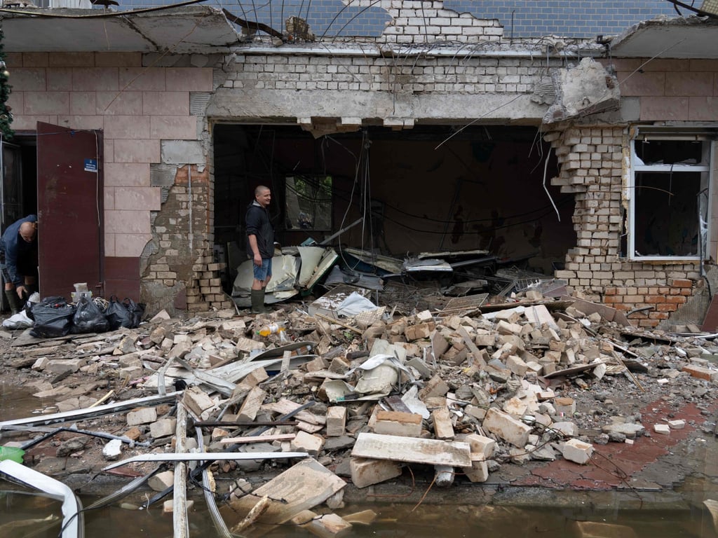 A resident clears debris from a shop destroyed by Russian shelling in Kherson on Monday. Photo: AFP