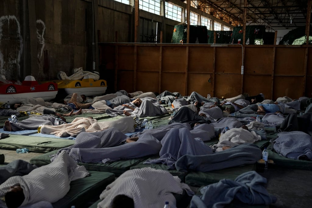 Survivors of a shipwreck sleep at a warehouse at the port in Kalamata town, Greece. Photo: AP