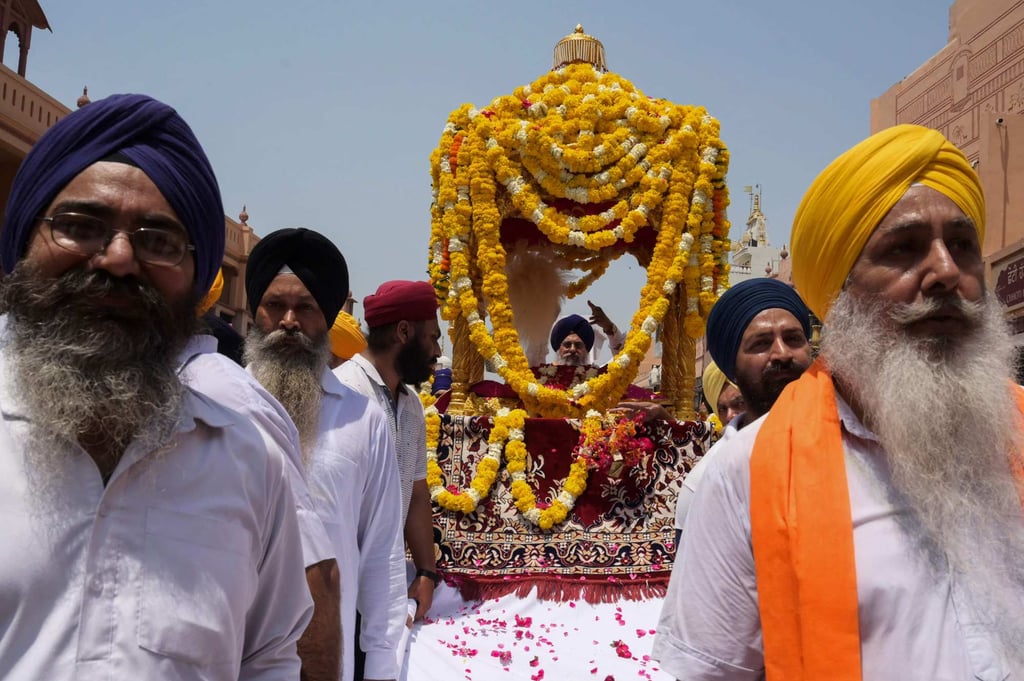 A Sikh priest sits in a palanquin behind the Guru Granth Sahib, the Sikh holy book, during a religious procession in Amritsar city, Punjab state. Photo: AFP A Sikh priest sits in a palanquin behind the Guru Granth Sahib, the Sikh holy book, during a religious procession in Amritsar city, Punjab state. Photo: AFP