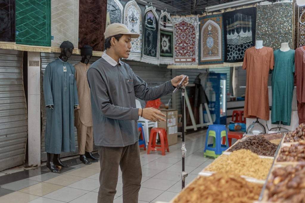 A shopkeeper shoots a promo video in front of his stall in Jakarta. Second-hand clothing sales are officially banned in Indonesia to protect the local textiles industry. Photo: Bloomberg