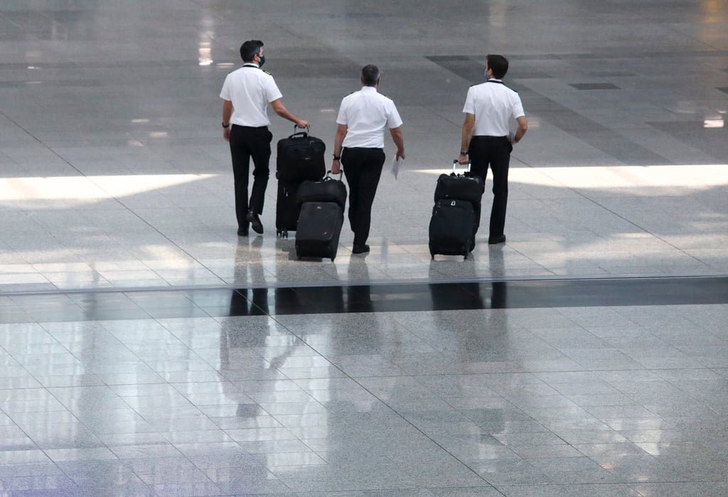 Pilots walk through the arrivals hall at Hong Kong International Airport. Photo: Yik Yeung-man Pilots walk through the arrivals hall at Hong Kong International Airport. Photo: Yik Yeung-man