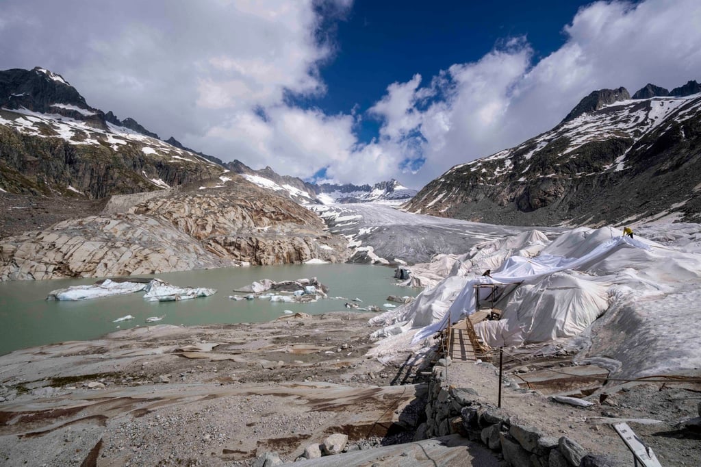 Chunks of ice float in a lake in front of the Rhone Glacier as people put covers over some of the glacier near Goms, Switzerland on Thursday. Photo: AP