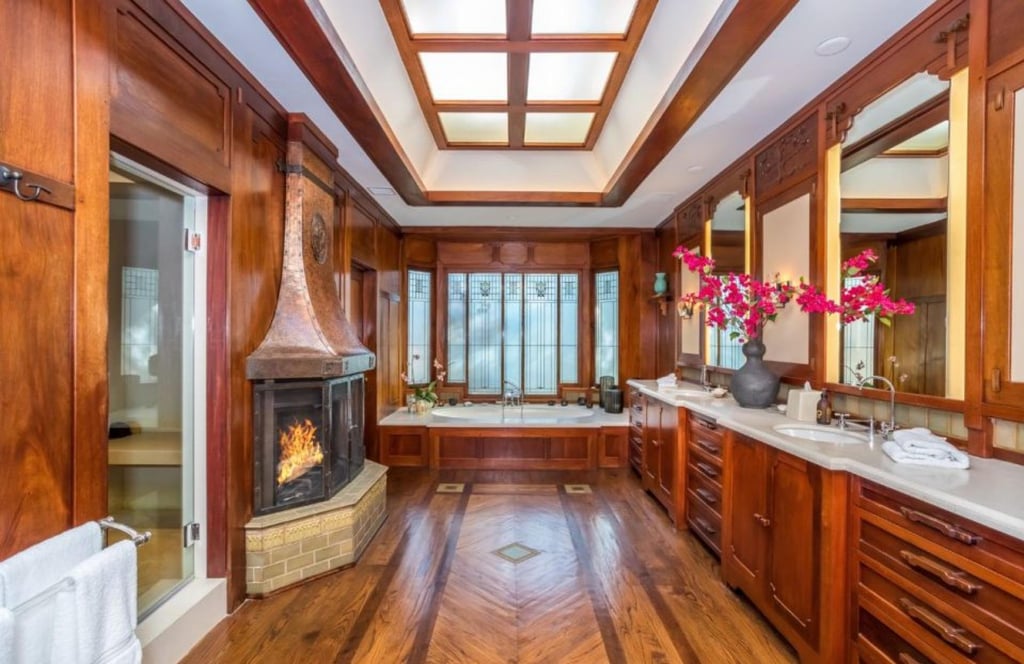 The wood-panelled primary bathroom features a copper-hooded fireplace. Photo: Daniel Dahler for Sotheby’s International Realty