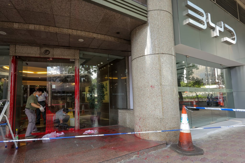 Cleaners remove red paint from a door next to BYD’s Wan Chai showroom. Photo: Jelly Tse Cleaners remove red paint from a door next to BYD’s Wan Chai showroom. Photo: Jelly Tse
