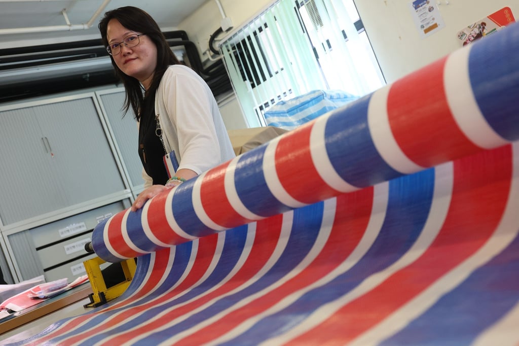 New Life Psychiatric Rehabilitation Association workshop manager Carmen Au with a roll of red, white and blue material at a workshop in Shek Kip Mei, in Sham Shui Po district. Photo: Edmond So New Life Psychiatric Rehabilitation Association workshop manager Carmen Au with a roll of red, white and blue material at a workshop in Shek Kip Mei, in Sham Shui Po district. Photo: Edmond So