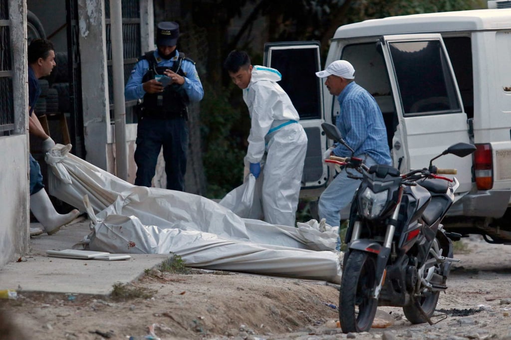 Forensic staff remove the body of one of the 11 people killed in a pool hall in Choloma, Cortes province, Honduras on Sunday. Photo: AFP