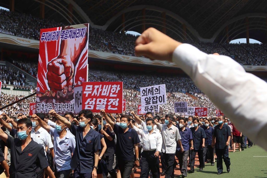 People take part in a mass rally at the May Day Stadium in Pyongyang to mark what the anniversary of what North Korea calls “the struggle against US imperialism” on Sunday. The poster reads “Let us mercilessly beat the puppet group of traitors!” Photo: AP