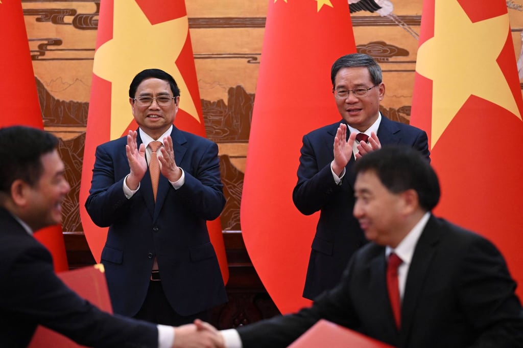 Chinh and Li applauding during a signing ceremony on Monday. Photo: AFP