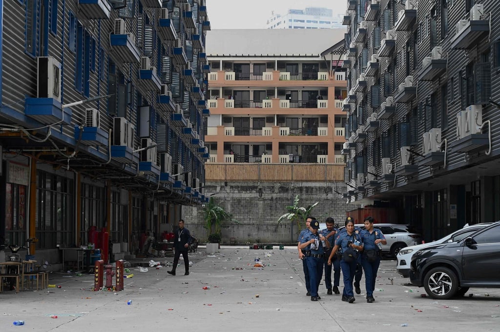 Officers walk inside the compound in Metro Manila that was raided by police on Tuesday. Victims of the cybercrime group were lured with high salary offers that failed to materialise, officials said. Photo: AFP Officers walk inside the compound in Metro Manila that was raided by police on Tuesday. Victims of the cybercrime group were lured with high salary offers that failed to materialise, officials said. Photo: AFP