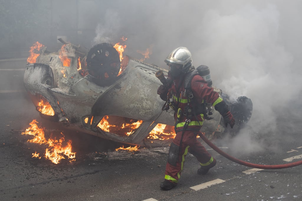 Firefighters extinguish burning cars during protests in the Parisian suburb of Nanterre on Thursday as anger grows over the police killing of a teenager. Photo: Abaca via Zuma Press / TNS