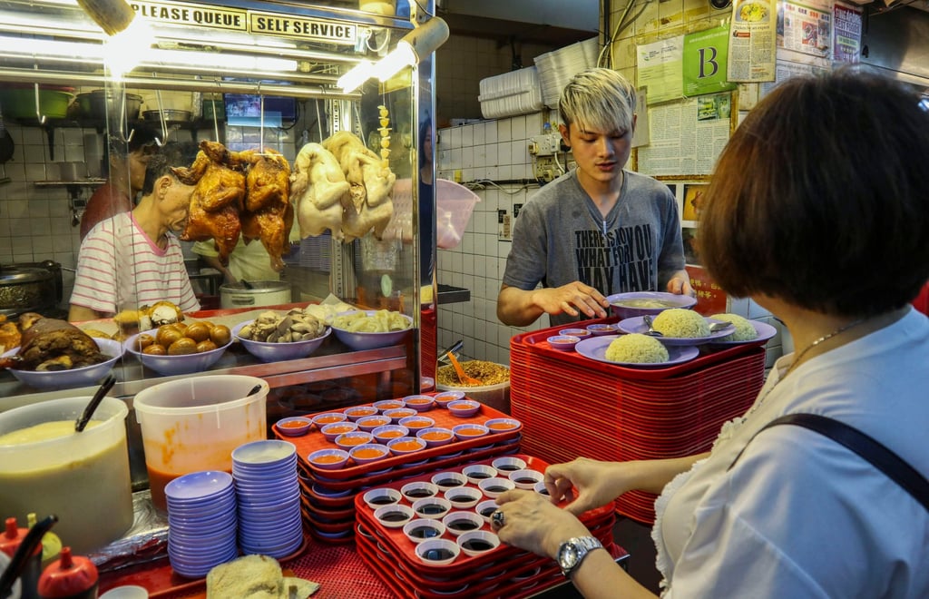 A customer waits for her order of Hainanese chicken rice – Singapore’s de facto national dish – at a hawker centre in Katong Shopping Centre. Photo: Roy Issa