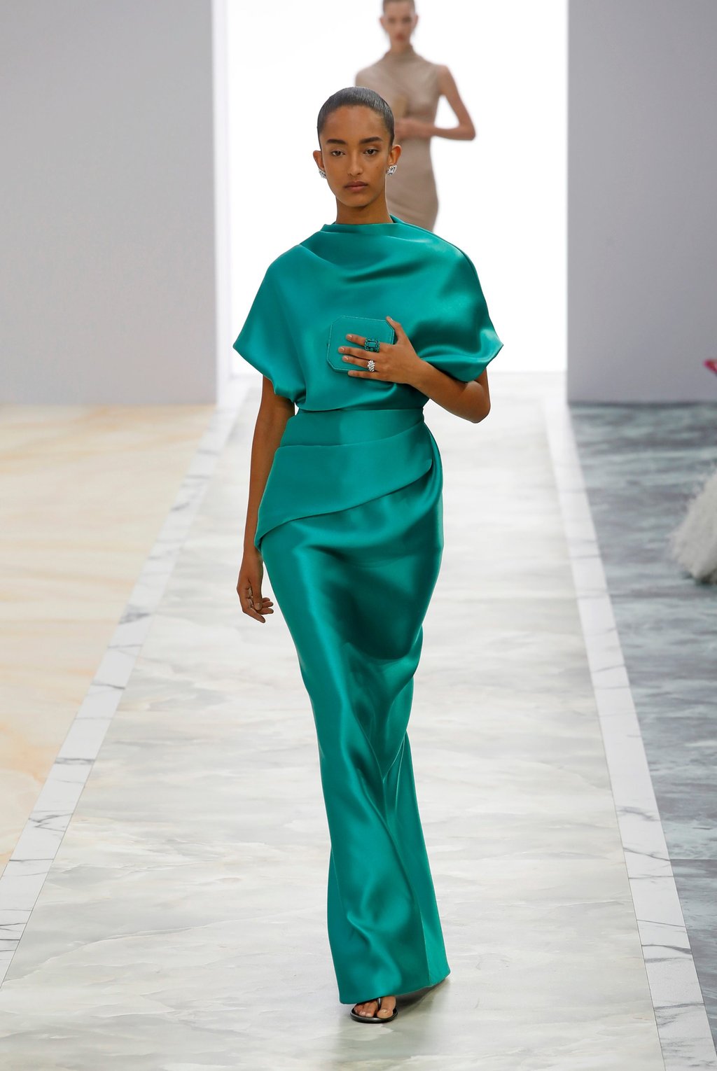 One piece was a fluid emerald green satin gown that cascaded down the model’s body, shimmering with the dynamism of a precious gem. Photo: Xinhua One piece was a fluid emerald green satin gown that cascaded down the model’s body, shimmering with the dynamism of a precious gem. Photo: Xinhua