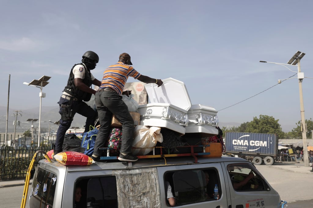 A policeman checks a driver’s cargo that includes coffins in Port-au-Prince. Photo: AP