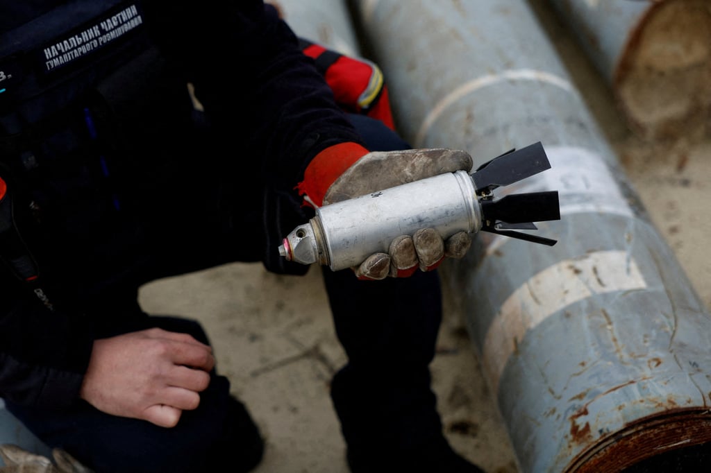 A Ukrainian military serviceman holds a defused cluster bomb from an MSLR missile that a Ukrainian munitions expert said did not explode on impact, in the Kharkiv region, Ukraine in October. Photo: Reuters