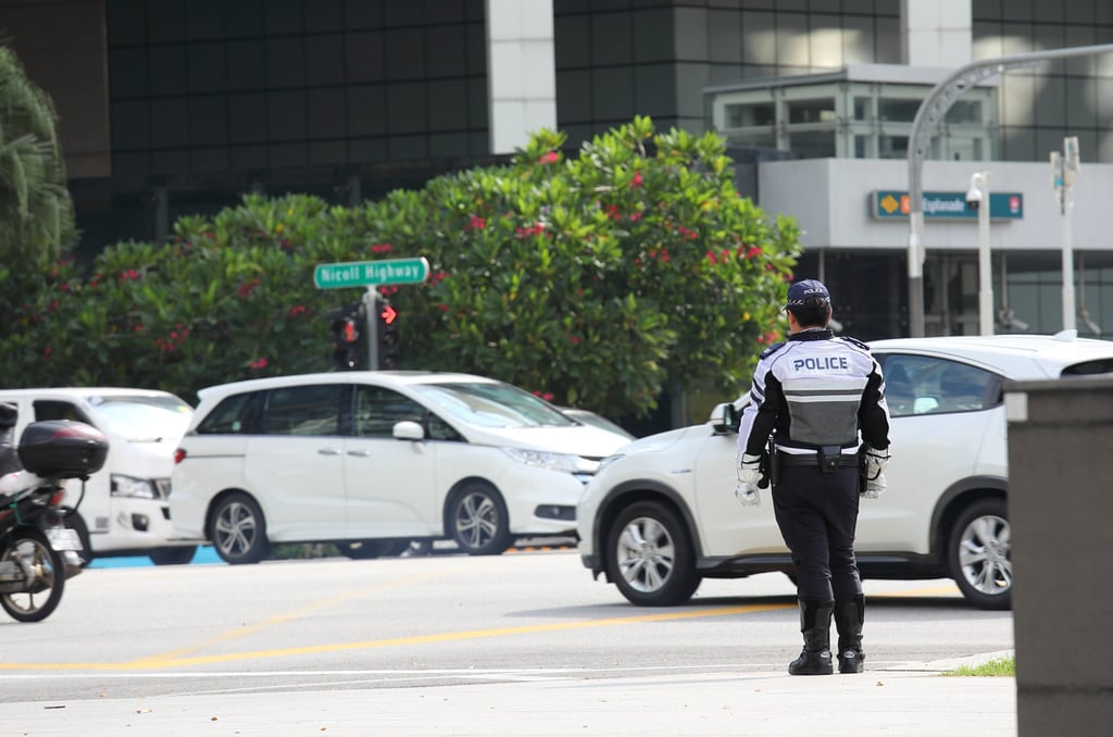 A traffic police officer watches traffic in downtown Singapore. Photo: Shutterstock