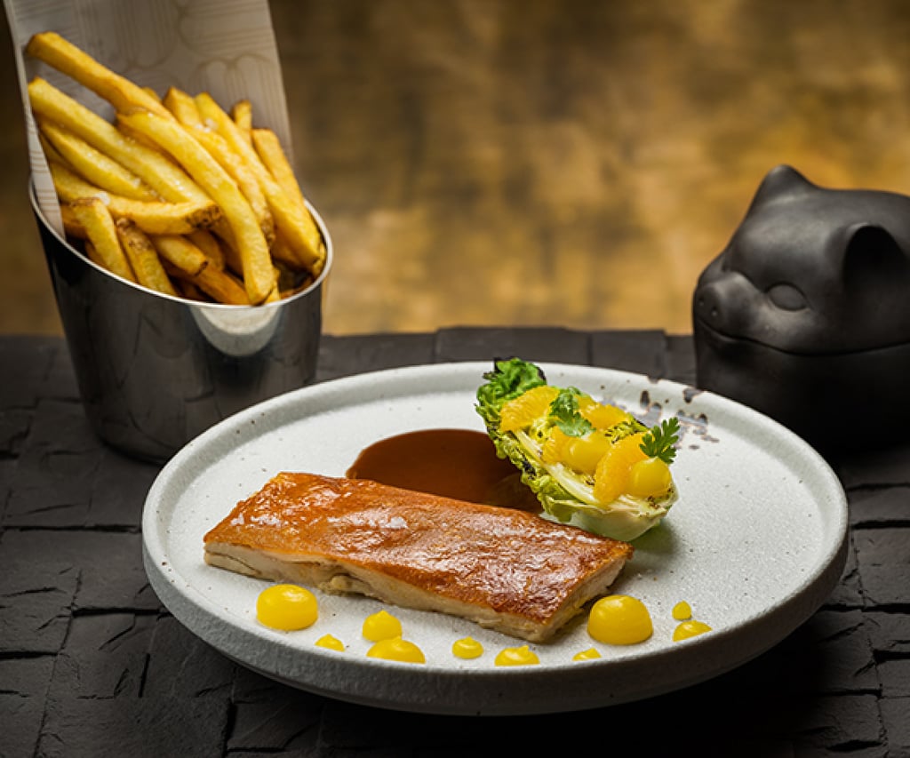 Crispy suckling pig with French fries and orange salad. Photo: Handout