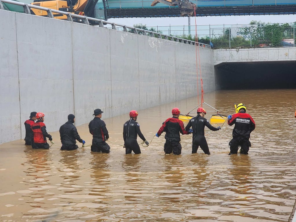 Rescuers try to reach people trapped in a flooded tunnel. Photo: Handout/National Fire Agency/AFP Rescuers try to reach people trapped in a flooded tunnel. Photo: Handout/National Fire Agency/AFP