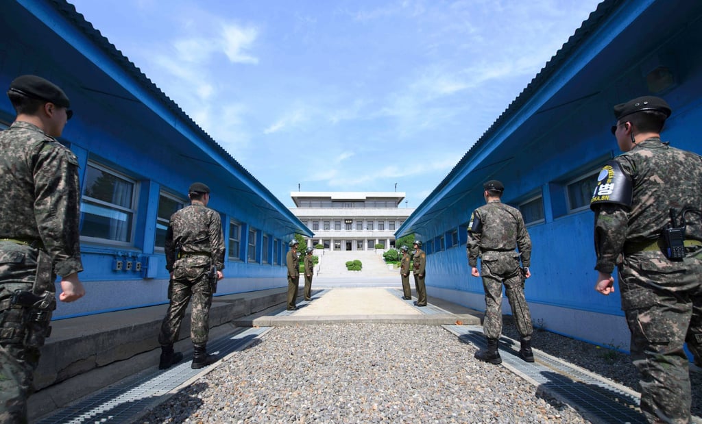 South Korean soldiers (front) and North Korean soldiers (rear) stand guard before the military demarcation line in the demilitarised zone. Photo: AFP –