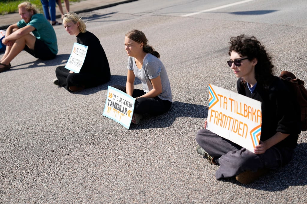 Greta Thunberg, centre, and other activists block the entrance to an oil facility in Malmo, Sweden on Monday. Photo: AP