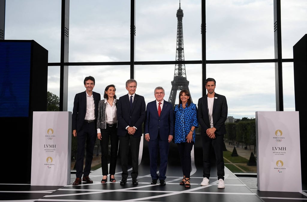 French government and Olympics officials pose for a group photo with CEO of LVMH holding company Antoine Arnault (far left) and LVMH head Bernard Arnault (third left) during a meeting after LVMH was named as final premium sponsor of 2024 Paris Olympics, in Paris, on July 24. Photo: AFP French government and Olympics officials pose for a group photo with CEO of LVMH holding company Antoine Arnault (far left) and LVMH head Bernard Arnault (third left) during a meeting after LVMH was named as final premium sponsor of 2024 Paris Olympics, in Paris, on July 24. Photo: AFP