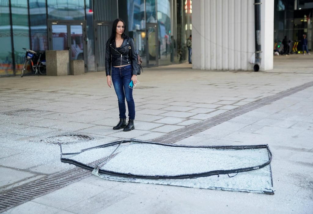 A woman stands next to broken glass pane outside a damaged office building in the Moscow City business district after a Ukrainian drone attack in Moscow, Russia, on Sunday. Photo: Reuters