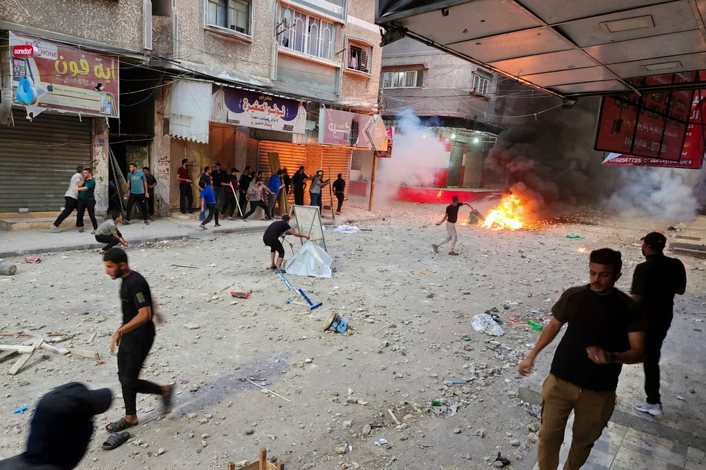 Palestinians throw stones and burn tyres during a protest against power cuts and difficult living conditions, in Khan Younis, southern Gaza Strip on Sunday. Photo: AP