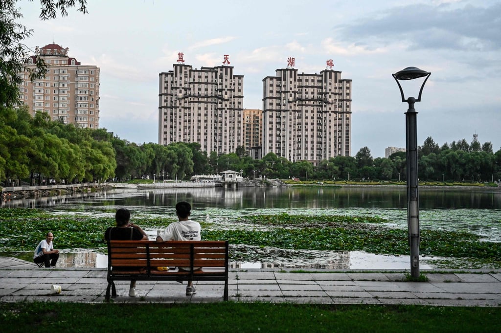 This photo taken on July 4, 2023 shows people relaxing by a lake near residential buildings in Hegang city in northeastern China’s Heilongjiang province. Photo: AFP This photo taken on July 4, 2023 shows people relaxing by a lake near residential buildings in Hegang city in northeastern China’s Heilongjiang province. Photo: AFP