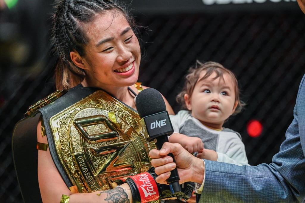 Angela Lee with her baby daughter in the cage after her victory over Stamp Fairtex at ONE X.