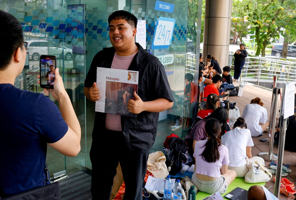A fan poses with a Taylor Swift vinyl album as he waits to buy Taylor Swift concert tickets at a post office in Singapore. Photo: Reuters A fan poses with a Taylor Swift vinyl album as he waits to buy Taylor Swift concert tickets at a post office in Singapore. Photo: Reuters