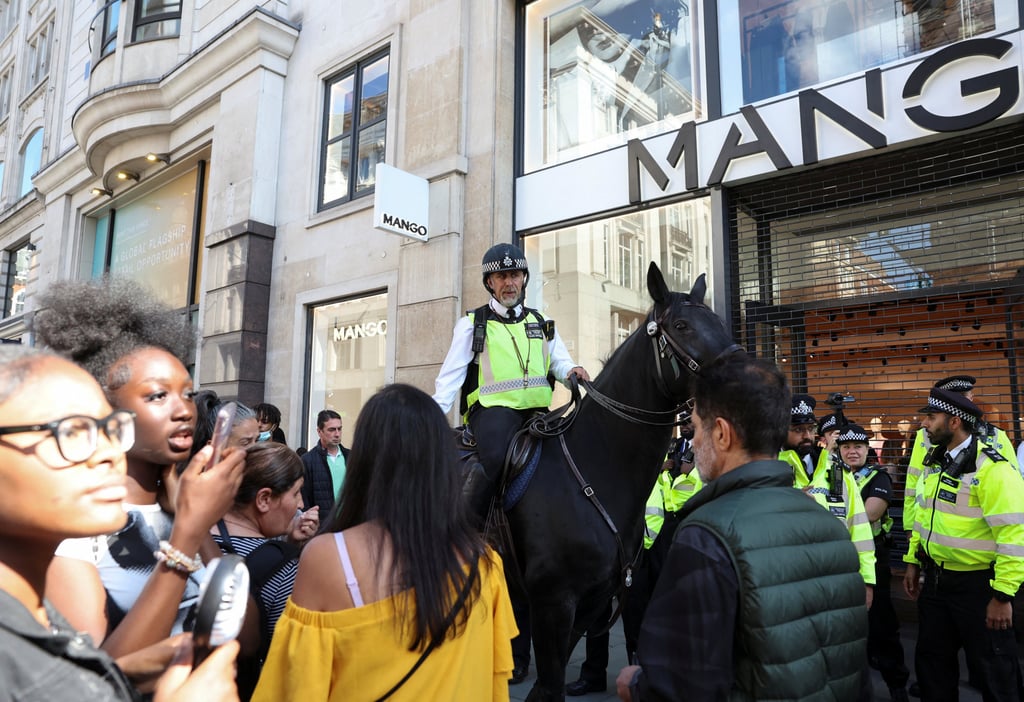 People walk past a mounted police officer, amid disrupters being expected to steal from shops on Oxford Street in London on Wednesday. Photo: Reuters