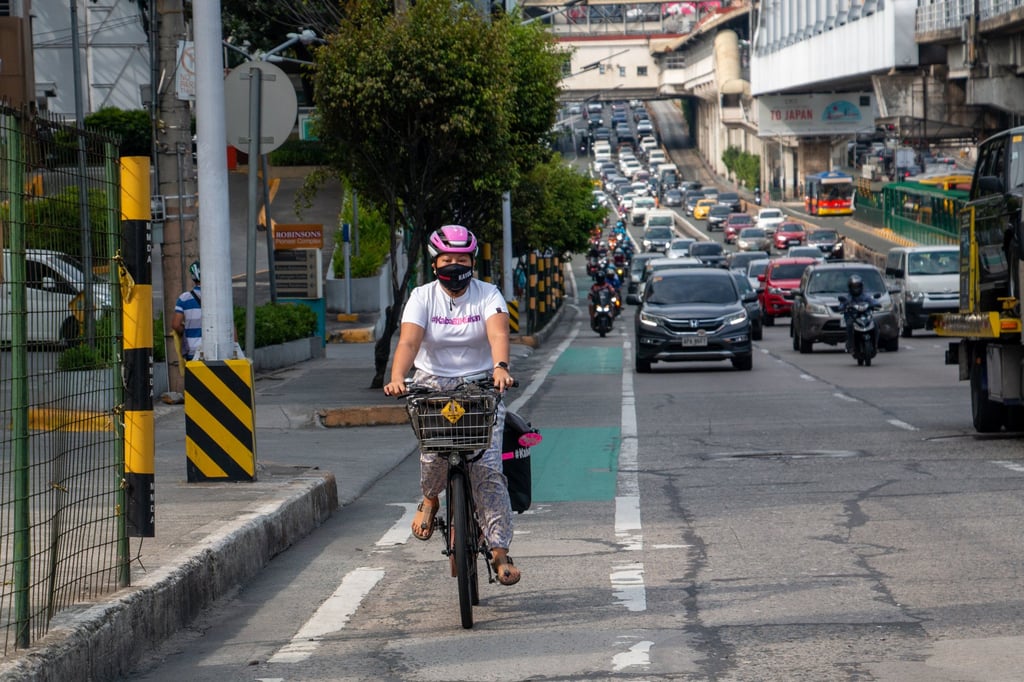 Jaramia Amarnani, 41, braves unfriendly drivers and motorcycle-filled bike lanes in the Metro Manila area. She has a sign on the back of her bike saying ‘Working Mom, Pass With Care’. Photo: Jhesset O. Enano Jaramia Amarnani, 41, braves unfriendly drivers and motorcycle-filled bike lanes in the Metro Manila area. She has a sign on the back of her bike saying ‘Working Mom, Pass With Care’. Photo: Jhesset O. Enano