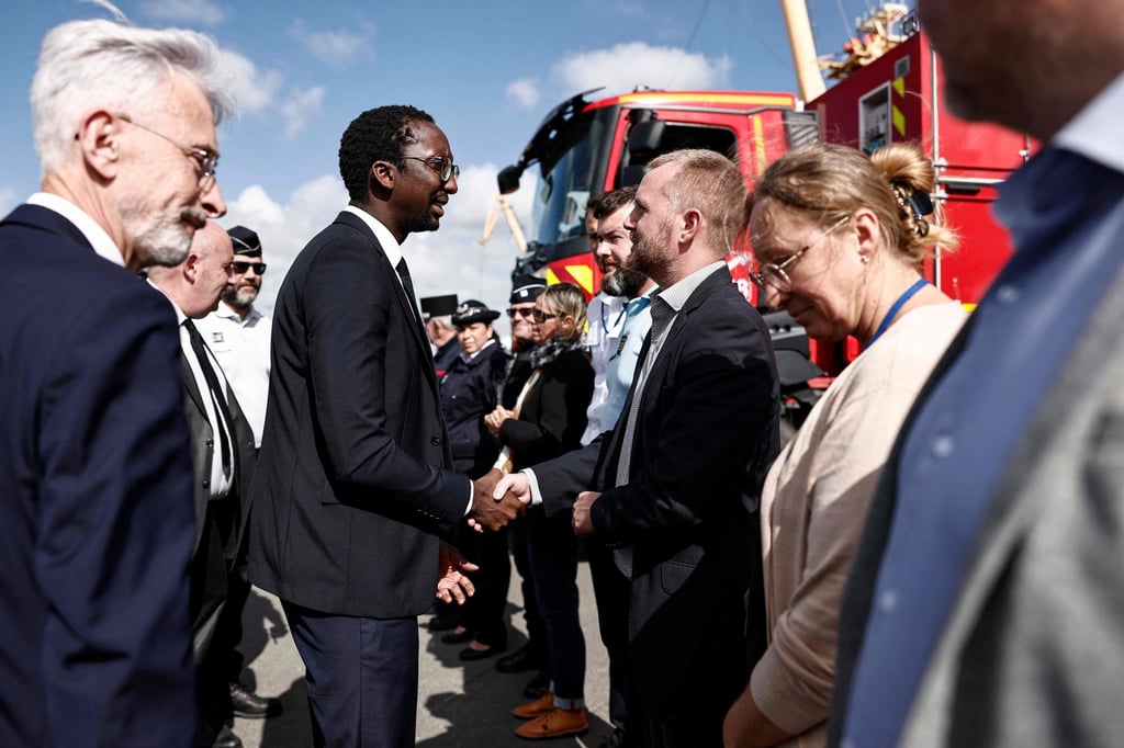 French Secretary of State for the Sea Herve Berville, second left, shakes hands next to French General Secretariat for the Sea Didier Lallement, left, at Calais harbour on Saturday. Photo: AFP