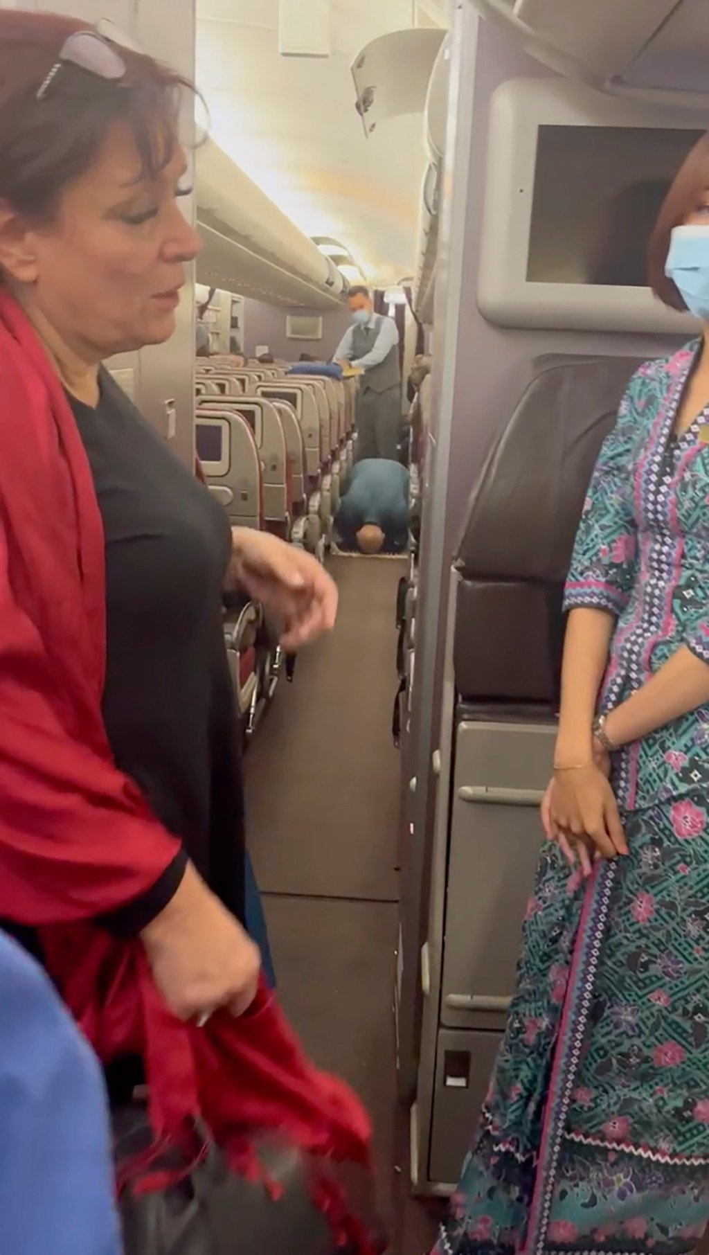 In this image from a video a passenger prays, centre, during the flight from Australia to Malaysia. Photo: AP In this image from a video a passenger prays, centre, during the flight from Australia to Malaysia. Photo: AP