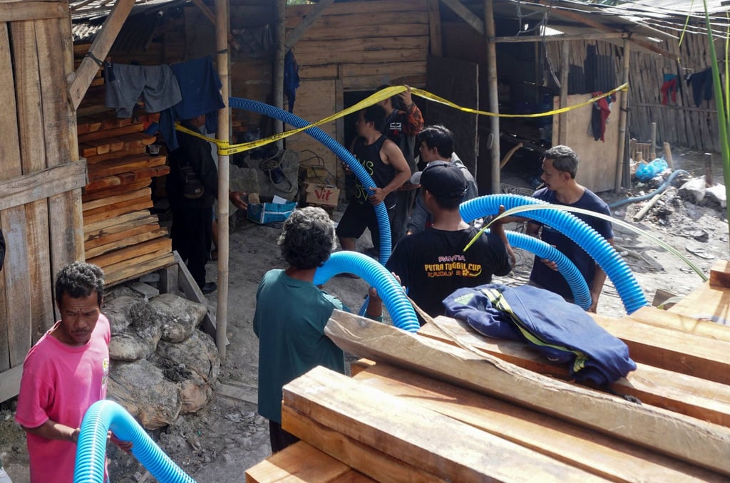 Rescuers insert a hosepipe to extract water from an illegal gold mining pit in Banyumas, Indoneia, last month. Photo: AFP