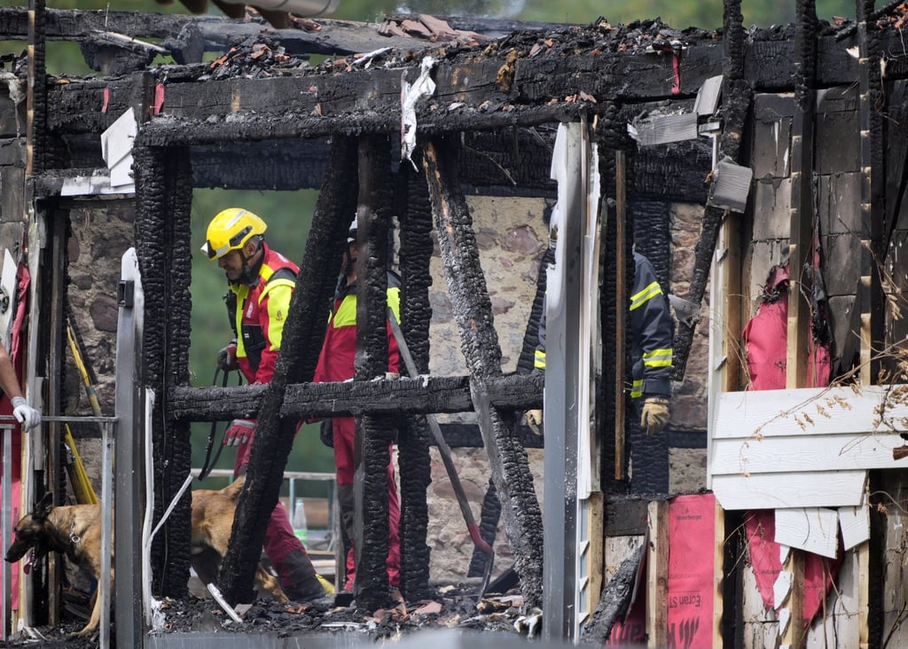 Firefighters and a sniffer dog work at a burned building after a fire broke out at a holiday home for disabled people in Wintzenheim, France, in August 2023. Photo: EPA-EFE